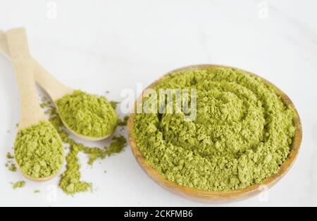 Poudre de Moringa dans un bol en bois avec sur fond blanc. Produit sain, superalimentation, vitamine Moringa Oleifera Banque D'Images