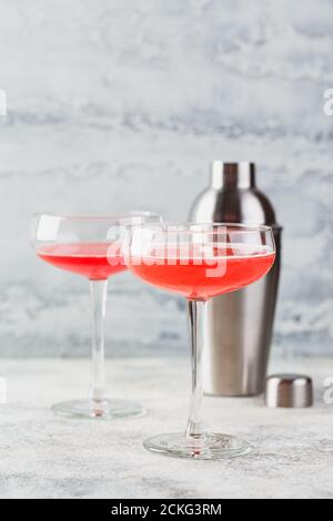 Cocktail alcoolique rose avec limonade, champagne ou Martini dans une coupe de champagne et un shaker à la lumière, cocktail comme Daiquiri, Cosmopolitan, Pink Mimos Banque D'Images