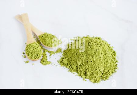 Poudre de moringa séchée dans des cuillères en bois sur fond blanc. Banque D'Images