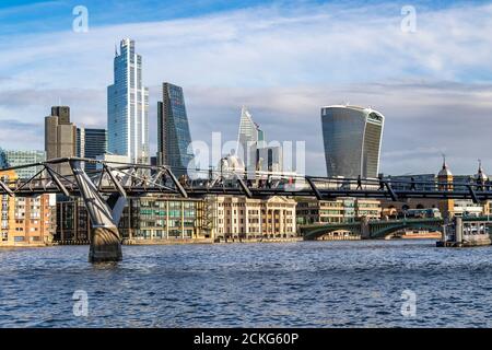 Personnes traversant le Millennium Bridge, une passerelle à travers la Tamise avec la ville de Londres en arrière-plan, Londres, Royaume-Uni Banque D'Images