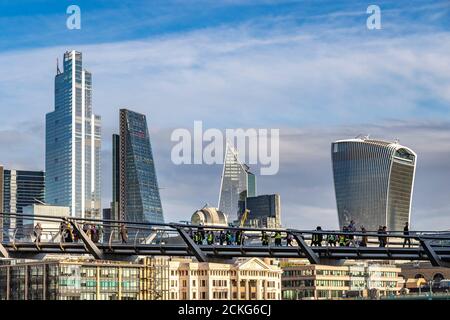 Personnes traversant le Millennium Bridge, une passerelle à travers la Tamise avec la ville de Londres en arrière-plan, Londres, Royaume-Uni Banque D'Images