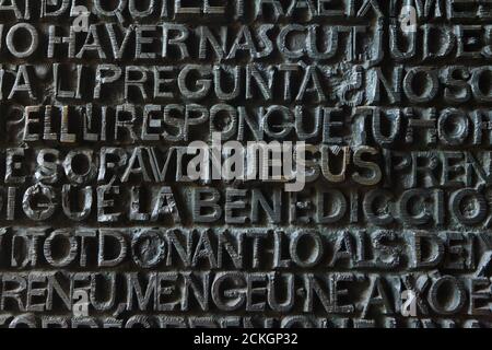 Nom de Jésus représenté dans les portes en bronze ouest de la Sagrada Família (Basílica de la Sagrada Família) conçu par le sculpteur moderniste espagnol Josep Maria Subirachs à Barcelone, Catalogne, Espagne. Le bronze est la partie de la façade passion de la basilique achevée en 1987. Banque D'Images