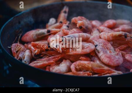 Crevettes frites. Faire cuire des crevettes dans une poêle au feu. Banque D'Images