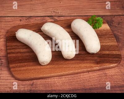 Saucisses traditionnelles blanches bavaroises (weisswurst) sur une planche de bois Banque D'Images