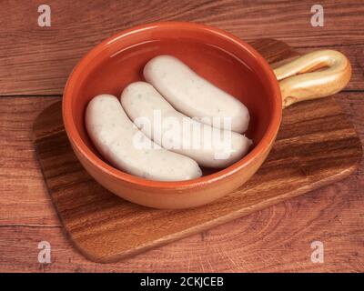 Saucisses traditionnelles blanches bavaroises (weisswurst) sur une planche de bois Banque D'Images