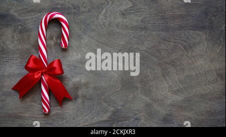 Décoration de Noël avec noeud rouge sur fond marron en bois, espace pour les copies, vue sur le dessus, plat. Décoration de Noël et du nouvel an. Banque D'Images