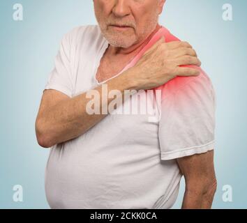 homme âgé avec douleur dans son épaule isolé à la lumière arrière-plan bleu Banque D'Images