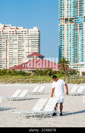 Miami Beach Florida, hispanique latin Latino immigrants ethniques minorités, adultes homme hommes hommes, préparation de chaises longues de location Banque D'Images