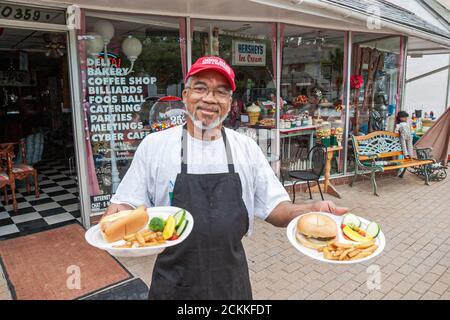 Newport News Virginia, historique Hilton Village Parlor Restaurant Black man homme serveur serveur servant commande déjeuner hot dog frites, travailleur en travail Banque D'Images