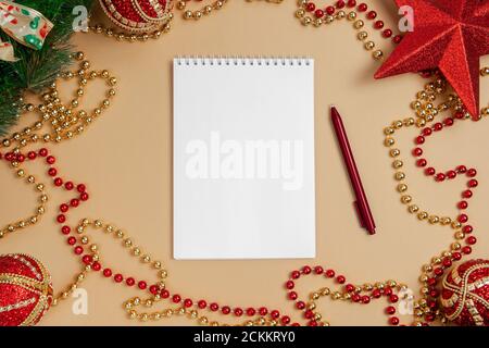 Mettez à plat un bloc-notes avec un stylo se trouve sur la table de Noël. Concept de Noël. Maquette. Banque D'Images