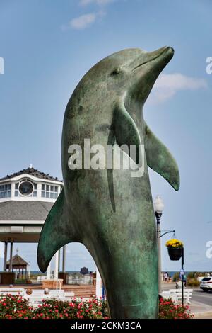 Rehoboth Beach, sculpture DE dauphin de bronze avec kiosque à musique en arrière-plan. Banque D'Images