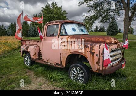 Un camion de pick-up amusant d'époque, la ruine totale des drapeaux canadiens. Banque D'Images