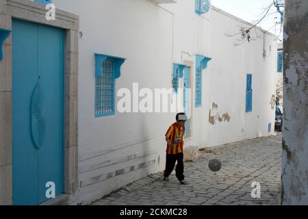 A Boy play soccer dans la vieille ville de Sidi Bou Said près de la ville de Tunis au nord de la Tunisie en Afrique du Nord, Tunisie, Sidi Bou Sair, mars 2009 Banque D'Images