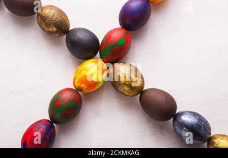 Lettres en bois multicolores composant les mots Happy easter et œufs colorés décoratifs sur fond blanc avec espace de copie. Banque D'Images