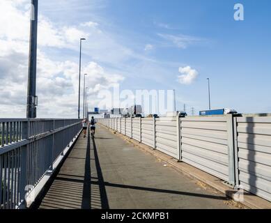 Jogging sur le pied et piste cyclable le long de la M5 Lorsqu'il traverse le long du kilomètre Avonmouth Bridge au-dessus du River Avon dans Somerset Royaume-Uni Banque D'Images