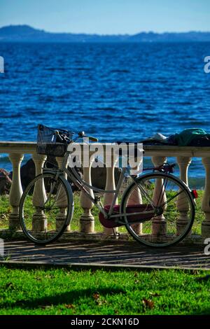 vélo stationné sur une main courante à colonnes le long de la rive de Lac Bolsena Banque D'Images