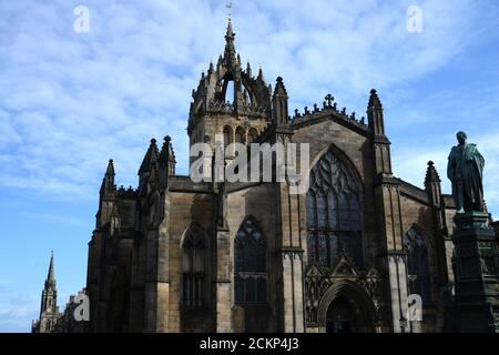 L'église historique de St Giles sur Royal Mile Édimbourg sous le soleil journée avec un ciel bleu profond et des nuages blancs plus sombres statues et vitraux Banque D'Images