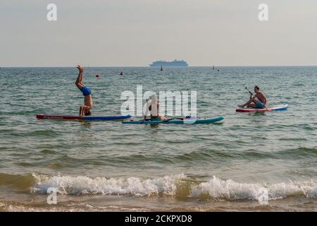 Boscombe, Bournemouth, Dorset, Royaume-Uni, 16 septembre 2020, Météo. Les gens sur la plage et dans la mer appréciant le troisième jour de septembre vague de chaleur avec le soleil chaud dans l'après-midi. Un paddleboarder essaie quelques acrobaties sur son plateau et tente une main. Crédit : Paul Biggins/Alamy Live News Banque D'Images