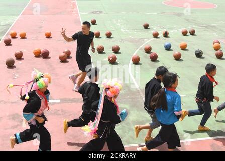 (200915) -- LINGYUN, 15 septembre 2020 (Xinhua) -- Shen Yequan (Top) et les élèves se réchauffent lors d'un cours de basket-ball à l'école primaire Lanjin, dans le canton de Sicheng, dans le comté de Lingyun, dans la région autonome de Guangxi Zhuang, dans le sud de la Chine, le 8 septembre 2020. Shen, 28 ans, est le seul professeur de PE de l'école du village. Il a été affecté à l'enseignement physique à l'école en 2018 après avoir obtenu un baccalauréat en sport. « en raison de nos efforts inconstants, les enfants ont un fort désir d'activités physiques. Je vais rester à mon poste ici pour aider les enfants ruraux à cultiver l'habitude de prendre p Banque D'Images