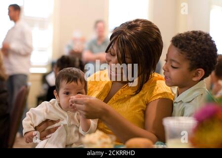 San Antonio, TX 25 novembre 2008 : programme Baptist Child & Family Services (BCFS) Preparation for Adult Living (PAL) dîner de Thanksgiving annuel pour les adolescents nourriciers qui passent des soins de l'État à la vie autonome avec peu ou pas de soutien familial traditionnel. Cheronda Tillman, travailleuse des services de protection des enfants, nourrit les enfants d'un client. ©Bob Daemmrich Banque D'Images