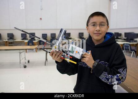 Austin, Texas, 5 décembre 2008 : un garçon hispanique de sixième année présente des créations de robotique pour les parents à la fin d'un semestre de travail dans la classe de robotique avancée à la Kealing Middle School à Austin. Il s'agit d'une mitrailleuse qui tire des granulés de plastique. ©Bob Daemmrich Banque D'Images