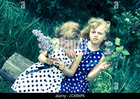 belle fille blonde assise sur le banc dans la prairie Banque D'Images