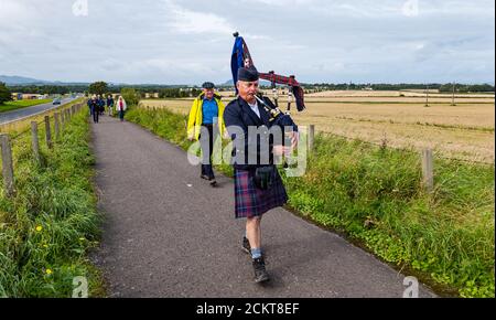 Un joueur de cornemuse mène une procession le long du site du champ de bataille lors de la commémoration de Pinkie Cleugh, East Lothian, Écosse, Royaume-Uni Banque D'Images