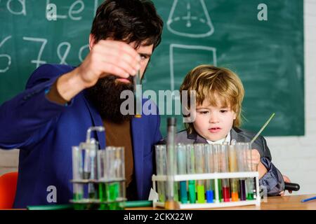 Tubes à essai pour enseignants et enfants. Leçon scolaire. La persévérance paye. Expérience chimique. Symptômes du TDAH à l'école. Programme scolaire. Garçon d'école mignon enfant expérimentant avec des liquides. Banque D'Images