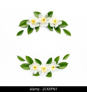 Cadre rond avec narcisse de fleur blanche, boutons de chamomiles, branches et feuilles isolées sur fond blanc. Plan plat, vue du dessus Banque D'Images