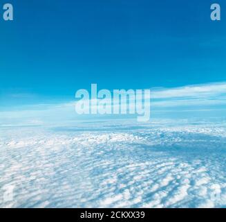 Nuages vus à travers une fenêtre d'avion Banque D'Images