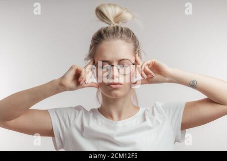 Jeune femme caucasienne concentrée avec les yeux fermés, tenant les doigts sur ses temples comme si essayer de se rappeler quelque chose d'important, isolé sur blanc Banque D'Images