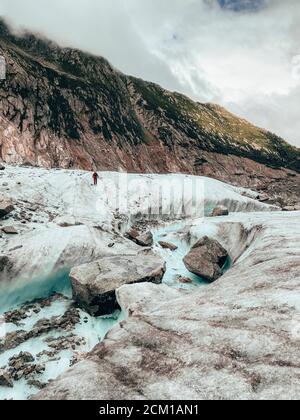 Randonnée femelle sur glacier traversant une rivière d'eau de fusion Mer de glace Banque D'Images