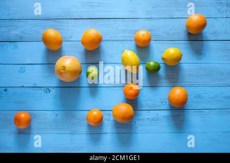 Agrumes entiers assorty de fruits colorés sur le milieu de fond texturé en bois bleu. Vue d'en haut. Copier l'espace. Banque D'Images