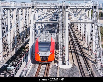 Le train à grande vitesse traverse le pont en approchant de la plate-forme de la gare. Banque D'Images