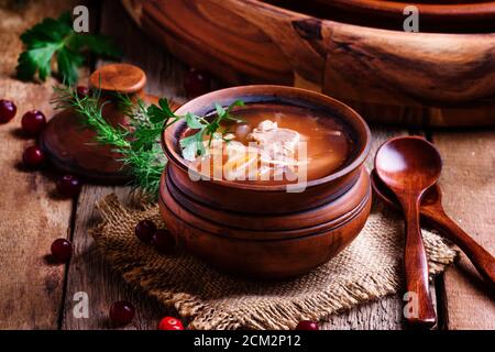 Soupe russe traditionnelle de choucroute, viande et pommes de terre dans un pot d'argile, fond de bois vintage, style rustique, concentration sélective Banque D'Images