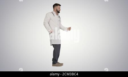 Un médecin arabe dansait et s'amuse sur fond de dégradé. Banque D'Images