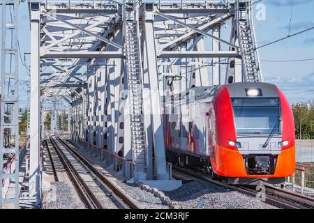 Le train à grande vitesse traverse le pont en approchant de la plate-forme de la gare. Banque D'Images