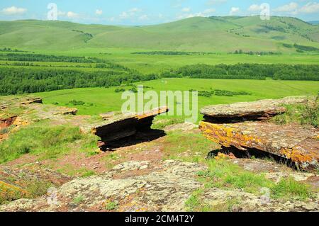 Deux pierres sacrificielles plates au sommet d'une colline surplombant une vallée pittoresque. Coffres de Mountain Range, Khakassia, Sibérie du Sud, Russie. Banque D'Images