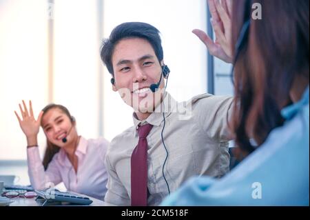 Groupe de jeunes hommes d'affaires en équipe avec micro-casque et ordinateur au bureau. Concept d'assistance aux entreprises. Banque D'Images