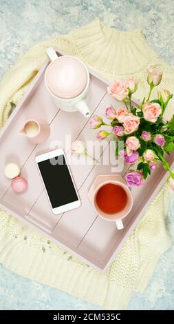 Décor rose blush espace de travail confortable avec clavier smartphone thé et rose sur un élégant fond texturé en marbre blanc. Vue de dessus de blog héros Banque D'Images