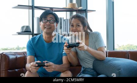 Un vieil homme et une femme jouant à un jeu vidéo à la maison Banque D'Images