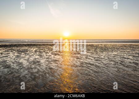 Magnifique coucher de soleil sur la plage de sable au Danemark. Fond de nature ensoleillé. Ciel clair avec le soleil Banque D'Images