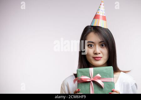 Joyeuse heureuse jeune femme asiatique tenant une boîte cadeau, enrayant avec joie. Émotions positives, célébration, People Comcept Banque D'Images