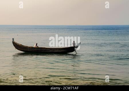 La vie des pêcheurs traditionnels au Kerala, bateau de pêche en bois, pêcheur jetant le filet dans le rivage, pêcheur répare le filet de pêche, Banque D'Images