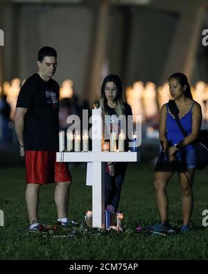 Parkland, États-Unis d'Amérique. 16 février 2018. PARKLAND, FL - 16 FÉVRIER : une jeune femme place des fleurs sur un site commémoratif qui rend hommage aux victimes de la fusillade de masse à l'école secondaire Marjory Stoneman Douglas, au parc Pine Trail, le 16 février 2018 à Parkland, en Floride. La police a arrêté l'ancien étudiant Nikolas Cruz, âgé de 19 ans, pour avoir tué 17 personnes au lycée. Personnes: Atmosphère crédit: Storms Media Group/Alamy Live News Banque D'Images