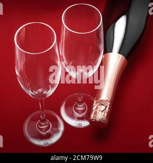 deux verres à champagne et une bouteille sur fond rouge, vue du dessus Banque D'Images