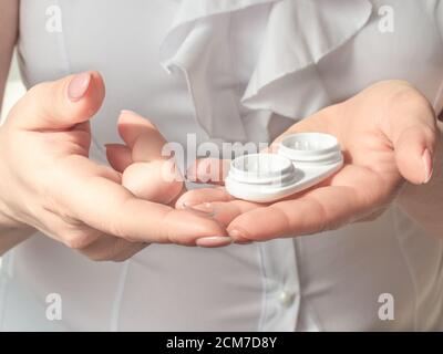 Vision et vision concept. Femme mains tenant un contenant blanc pour les yeux Banque D'Images