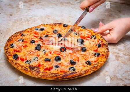 Faire une pizza à la maison avec de la tomate, des olives, du jambon et du fromage, faire cuire à la maison concept. Banque D'Images