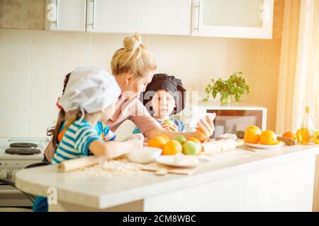 Mère et fille dans des robes avec téléphone. Sur la cuisine Banque D'Images