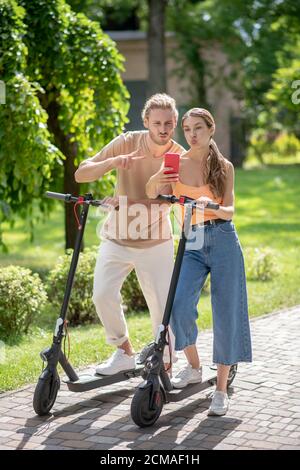 Jeune couple mignon faisant le selfie dans le parc Banque D'Images